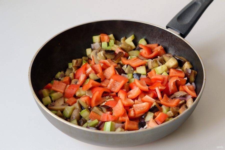 Добавьте лук и чеснок пропущенный через пресс. Спустя 1-2 минуты добавьте красный болгарский перец и помидор. 
