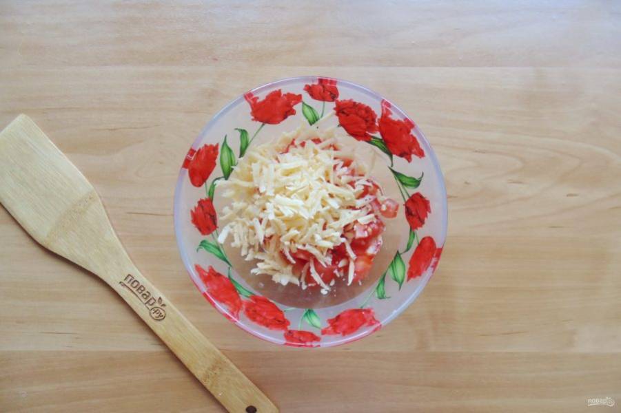 Сыр натрите на терке с крупными отверстиями и выложите в салатник с помидорами.