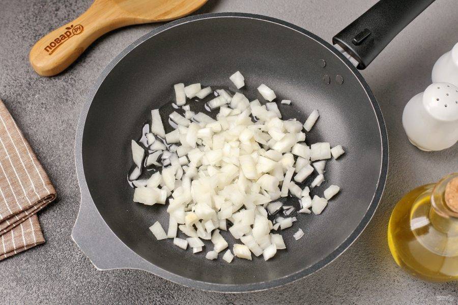 Разогрейте сковороду с маслом и выложите нарезанный кубиками лук.