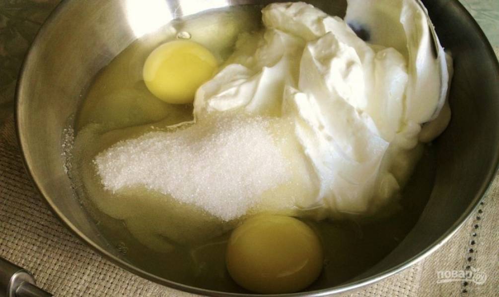 Теперь сделаем заливку. Для этого в миске при помощи венчика смешайте яйца, сахар (сахарную пудру), сметану.