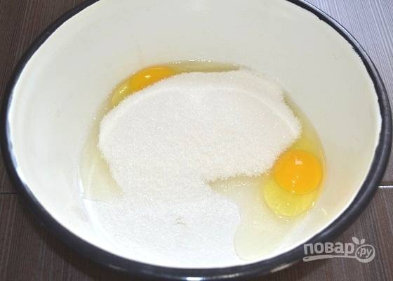2. В глубокую мисочку вбейте яйца, добавьте обычный и ванильный сахар. Взбейте до однородности.