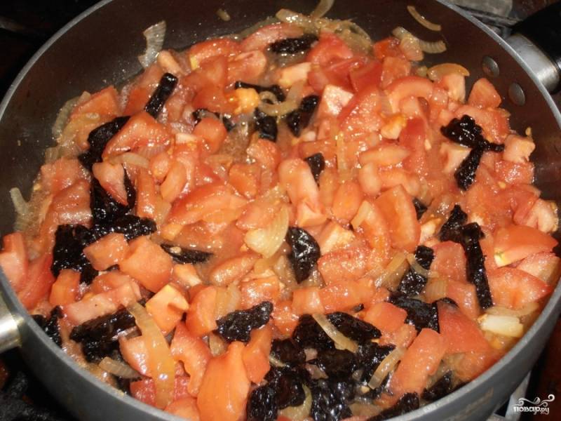 Обжаренное мясо снимите со сковороды и обжарьте на той же сковороде лук, добавьте к нему чернослив и помидоры и потушите минут 10.