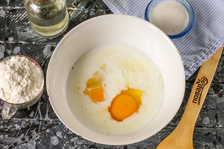 Молоко вылейте в глубокую емкость, вбейте туда же куриные яйца, всыпьте сахар и соль. Взбейте содержимое емкости в течение 1-2 минут.