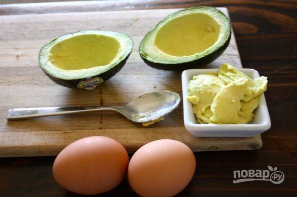 1.	Вымойте авокадо и разрежьте его на 2 части. Ложкой вычистите немного мякоть, чтобы было место для яйца, но не выковыривайте до кожуры. Обжарьте немного бекон. 