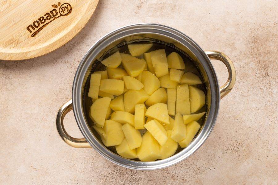 Картофель помойте, очистите от кожуры и нарежьте ломтиками среднего размера. Отварите в кипящей подсоленной воде до мягкости примерно 20-25 минут.