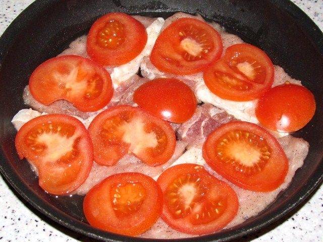 3.	Порежьте помидоры на тонкие кружочки. Начните формировать продукты для приготовления: положите на противень растительное масло, отбитое мясо, кусочек помидора, блюдо посолите.
