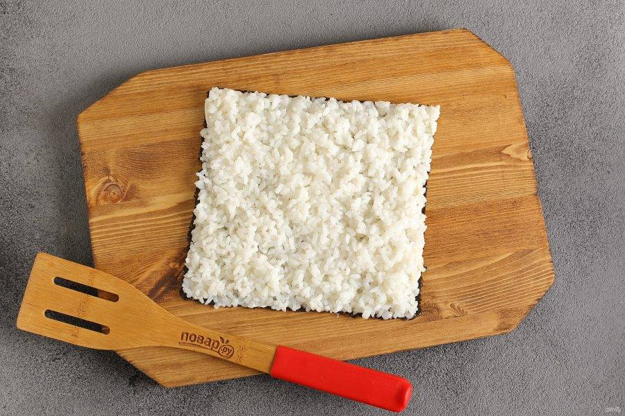 Выложите рис на предварительно промазанный майонезом лист нори.