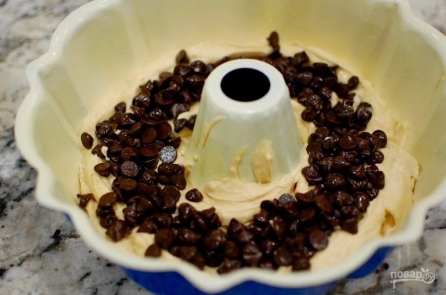 7.	Форму для выпечки смажьте маслом, вылейте в нее половину теста и добавьте 1 стакан шоколадной стружки.