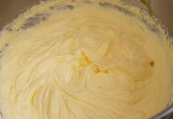 Размягченное масло растираем с сахаром, затем взбиваем. Продолжая взбивать, вводим яйца. Затем просеиваем муку с разрыхлителем и цедру лимона. Замешиваем тесто.