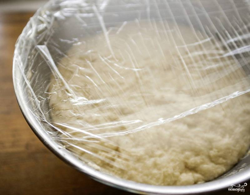 После трудоемкой раскатки и порционного ввода соды, замешиваем тесто опять в ровный колобок. Кладем его в просторную емкость и накрываем полиэтиленом или пакетом. Ставим в тепло, чтобы тесто отлежалось и немного поднялось.