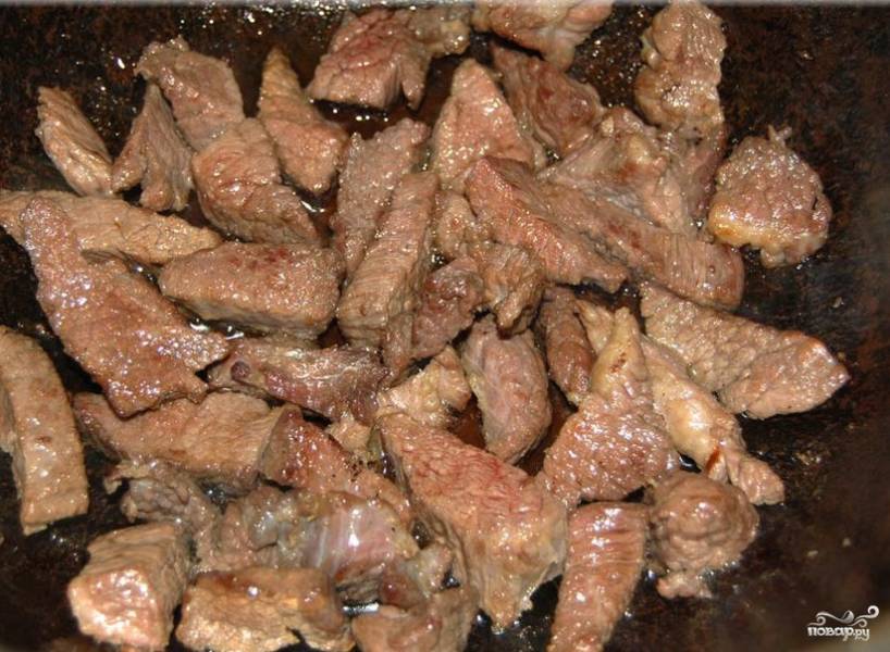 5. В сковороду с высокими бортами положить топленое масло и хорошо его разогреть. Отправить туда мясо и на сильном огне поджарить до румяной корочки.