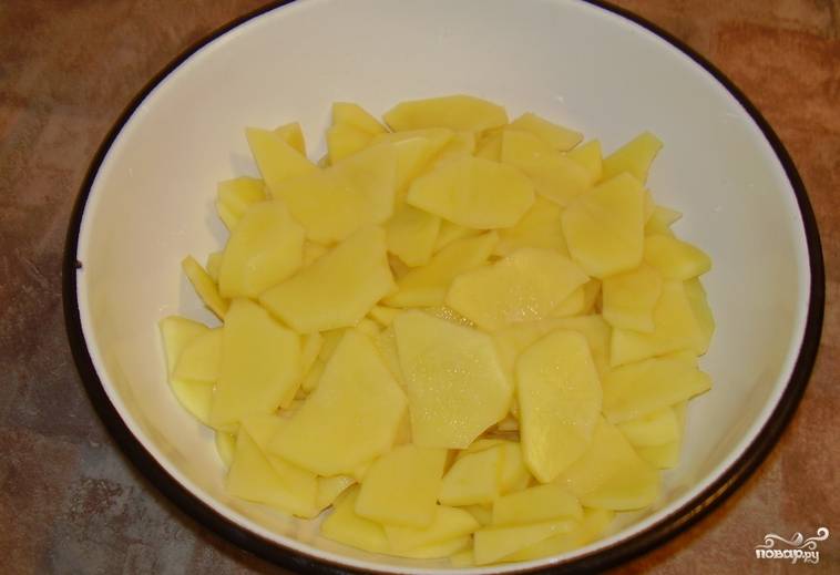 Картофель промываем, очищаем и нарезаем пластинками. Старайтесь делать пластинки одинаковой толщины, чтобы картофель равномерно пропекся.