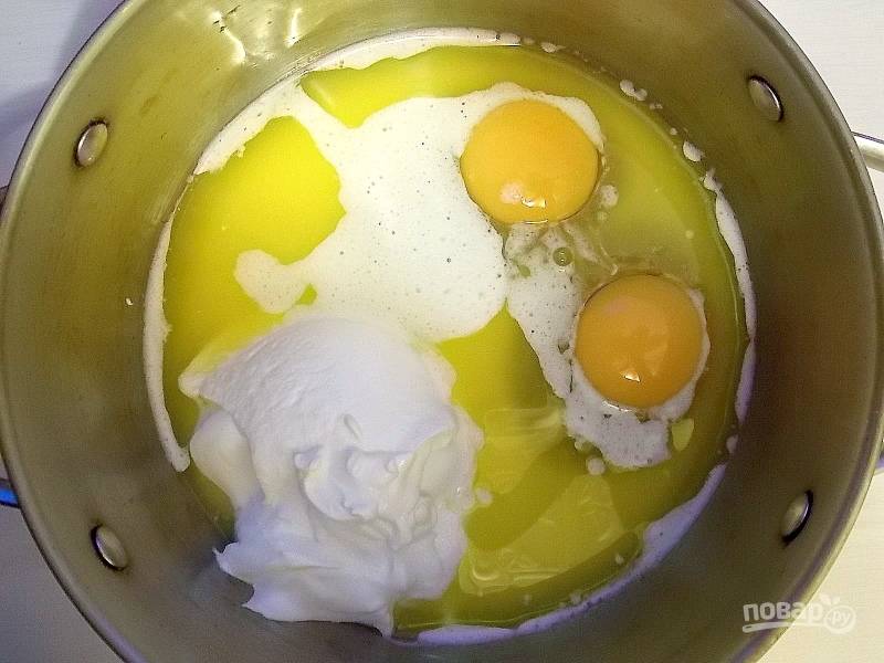 Смешайте яйца, растопленное масло и сметану до однородной массы.