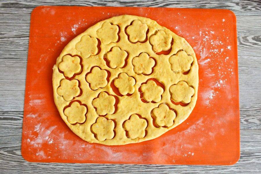 Тесто разделите на две части. Каждую часть раскатайте в пласт толщиной 0,5 см. Вырежьте формочками печенье. 