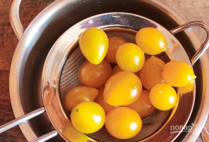 Для этого рецепта прекрасно подойдут небольшие помидоры черри желтого цвета. Они очень эффектно смотрятся на столе. Выложите их в дуршлаг и промойте под проточной водой. 