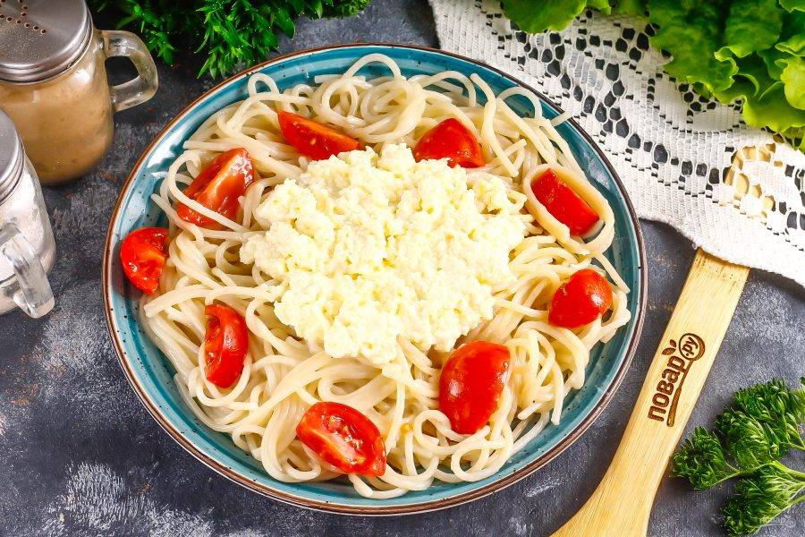 Выложите спагетти на тарелку и разровняйте по ней. В середину выложите творожный сыр. Поперчите блюдо.