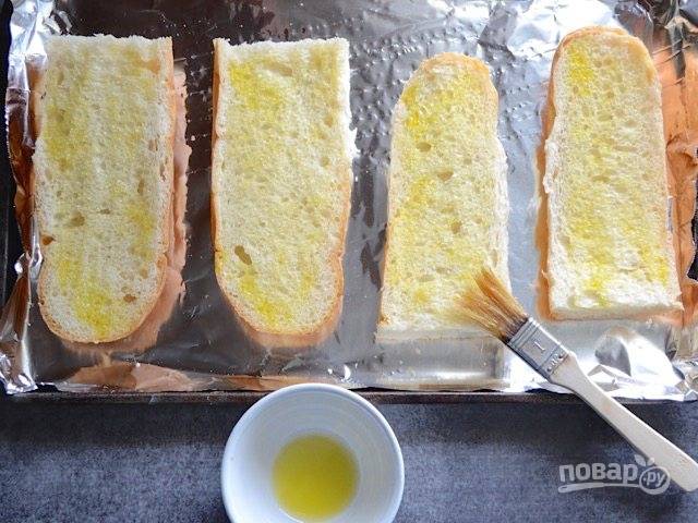 3.	Французский багет разрежьте пополам, затем каждую половинку еще вдоль. Выложите хлеб на противень и смажьте его растительным маслом. Отправьте хлеб на 2-3 минуты в разогретый до 180 градусов духовой шкаф.