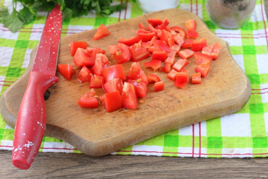 Нарежьте помидоры и почищенный сладкий перец кубиками.
