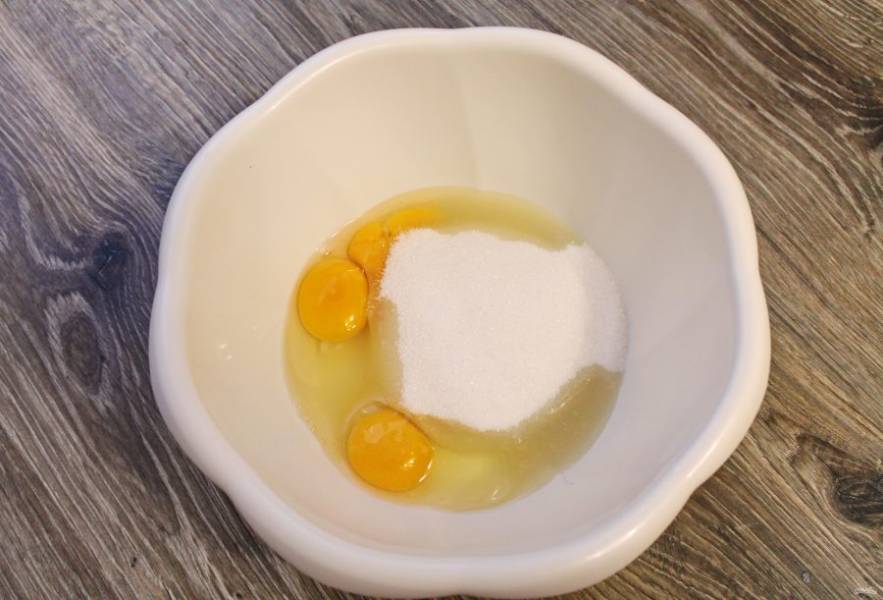 Разбейте в миску яйца, добавьте сахар и ванильный сахар. Все хорошенько взбейте.