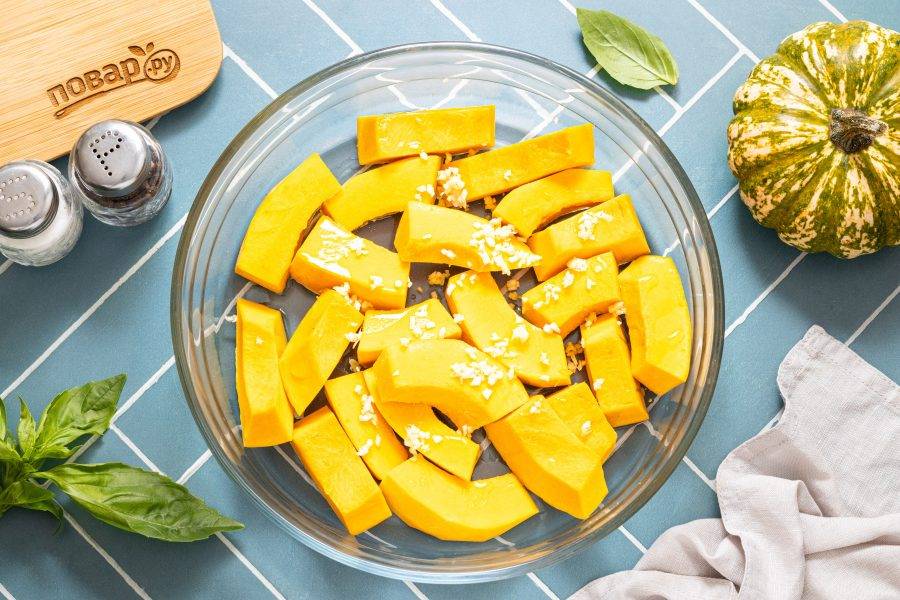 Зубчики чеснока очистите и мелко порубите ножом. Добавьте к тыкве.