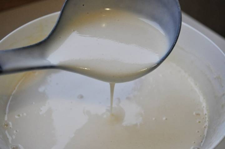 Приготовим тесто. Яйца взбиваем с сахаром до однородности. Добавляем молоко и просеянную муку, не прекращая взбивать. Оставляем тесто на 15 минут, затем вливаем масло и добавляем соду, перемешиваем.