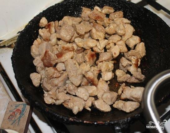 Кусок свинины вымойте и зачистите, нарежьте на квадратики около двух сантиметров шириной. Посолите и поперчите мясо. Обжарьте его на сильном огне на протяжении десяти минут в отдельной сковородке с добавлением растительного масла. 