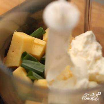 В чашу блендера кладем нарезанный кубиками сыр, чеснок, зеленый лук, сливочный сыр и сливки.