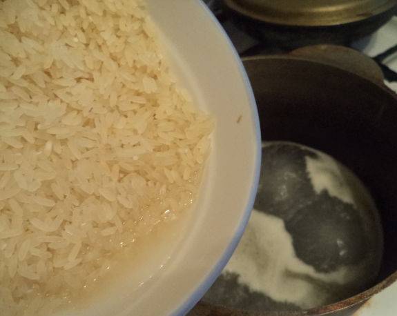 Посолите воду, добавьте немного сливочного масла. Всыпьте рис. Варите на медленном огне в течение трети часа, пока он не станет густым. 