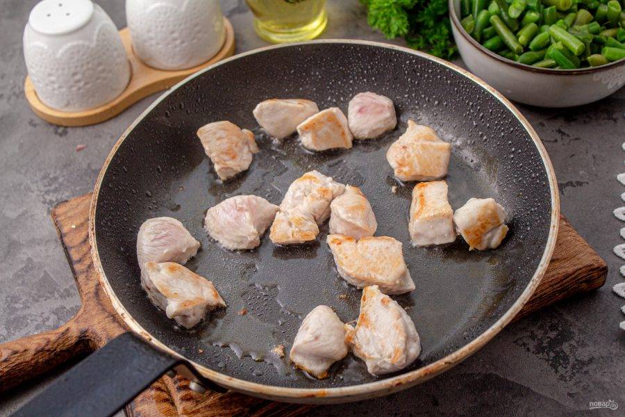 Куриное филе нарежьте средними кусочками. Выложите в сковороду с растительным маслом и обжарьте до румяности.