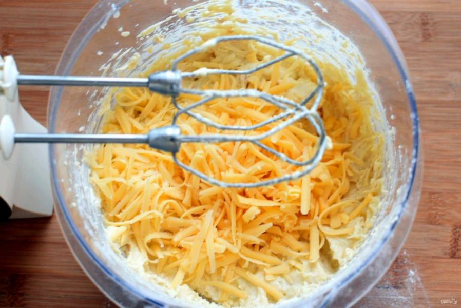 
Всыпьте просеянную с разрыхлителем смесь кукурузной и пшеничной муки, перемешайте до однородности, не слишком усердствуя. Добавьте  тертый сыр и вмешайте его в тесто.
