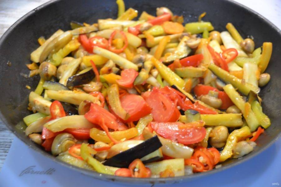 Добавьте к овощам в сковороду острый перец и помидор.