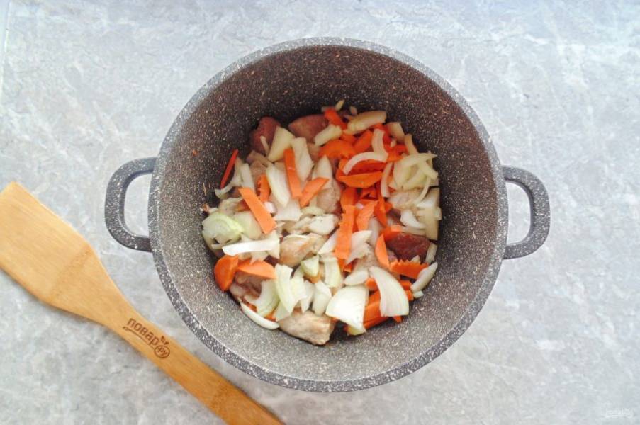 Лук и морковь очистите и помойте. Нарежьте соломкой морковь, а лук полукольцами. Добавьте к мясу. Налейте еще немного масла и жарьте овощи с мясом 5-7 минут, периодически перемешивая.