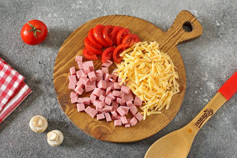 Сыр натрите на крупной терке, помидоры нарежьте дольками, колбасу измельчите кубиками.