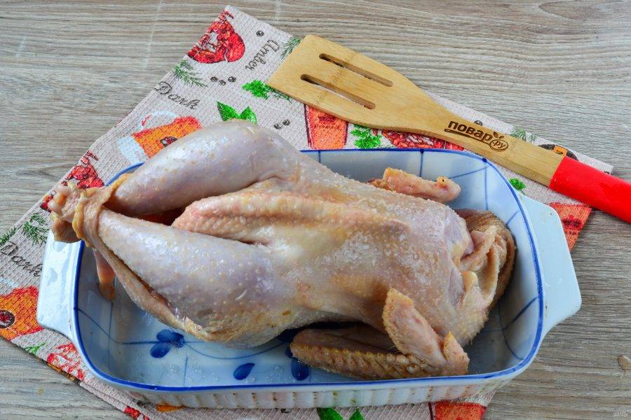 Курицу натрите оливковым маслом, а затем посолите. Можно немного натереть черным перцем или смесью специй для курицы. Переложите курицу в жаропрочную форму для запекания и отправьте в духовку, разогретую до 180 градусов. Время приготовления курицы зависит от самой курицы и ее веса. Если вы используете домашнюю курицу весом до 1,5 кг, то запекать ее вам придется не меньше часа, при чем в форму советую налить примерно 100 мл воды. Магазинную курицу готовьте 40-50 минут. Чтобы проверить готовность курицы, проткните грудку, если сок будет прозрачным, а само мясо белым, то курица готова. 
