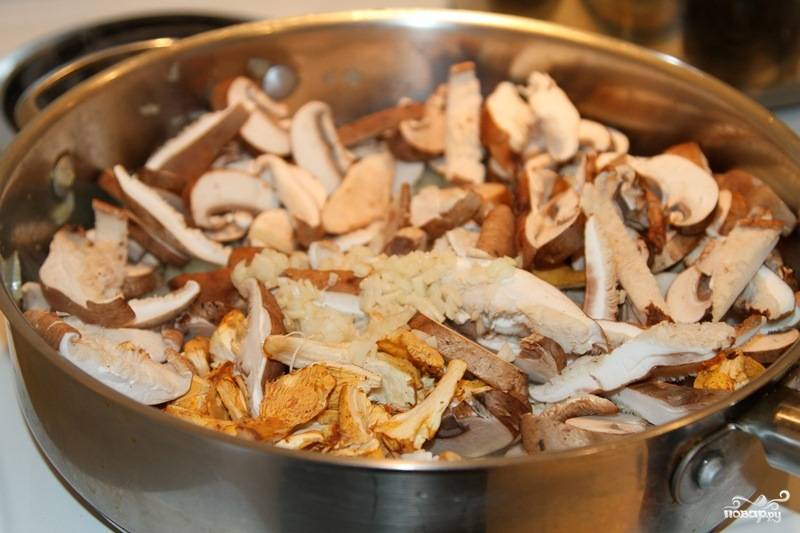 Когда лук приобрел золотистый оттенок, добавляем грибы и чеснок.