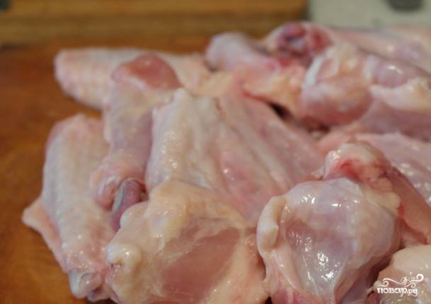 Куриные крылышки хорошенько вымойте. Если они были замороженными, то разморозьте мясо в микроволновой печке или при комнатной температуре. Разрубите их на порционные кусочки, обрежьте лишнюю кожу. 