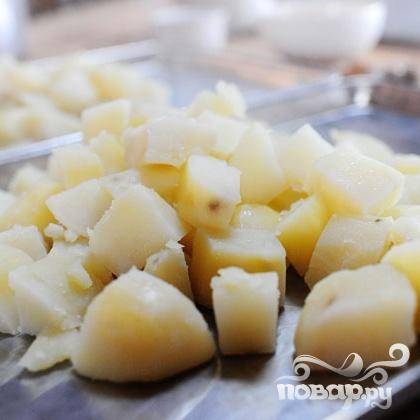 1. Картофель предварительно отварить до готовности. Нарезать кубиками. Разогреть духовку до 190 градусов. Выложить вареный картофель на противень и поставить в духовку на 10-15 минут, чтобы слегка подсушить его.
