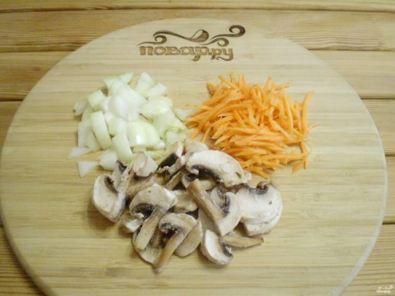 Тем временем порежьте мелко лук, морковь и грибы. Отправьте их на сковороду жариться на растительном масле до готовности.