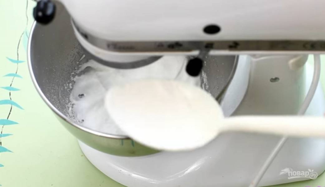 5.	Осторожно по одной ложке добавьте сахар к взбивающимся белкам. Взбивайте до тех пор, пока сахар полностью не растворится (это можно проверить пальцами).