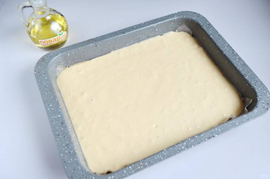 5. Форму застелите пергаментом, смажьте растительным маслом или кулинарным жиром. Перелейте тесто, разровняйте лопаткой.