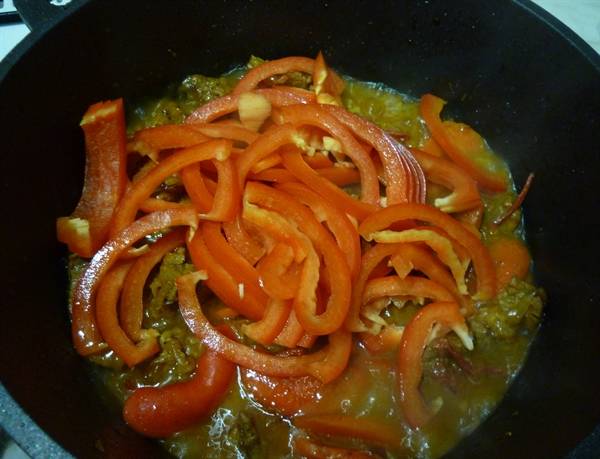 Обжарив помидоры, добавляем в казан тонко нарезанный болгарский перец.