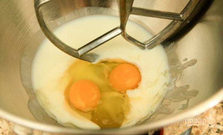 1.	В чашу миксера влейте пахту, добавьте сметану, вбейте куриные яйца, влейте теплую воду.