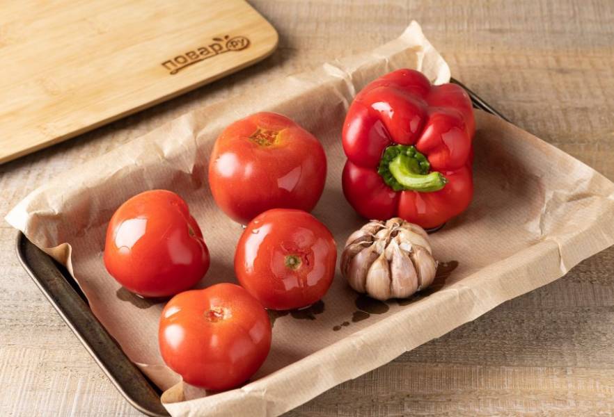 Болгарский перец и помидоры помойте, у помидор можно вырезать плодоножки. Чеснок очистите от лишней шелухи. Полейте все оливковым маслом и запекайте 30-40 минут в духовке при температуре 200 градусов.