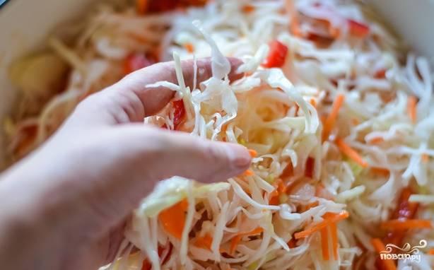 Вылейте рассол в капусту и  с помощью рук распределите по всей массе овощей.