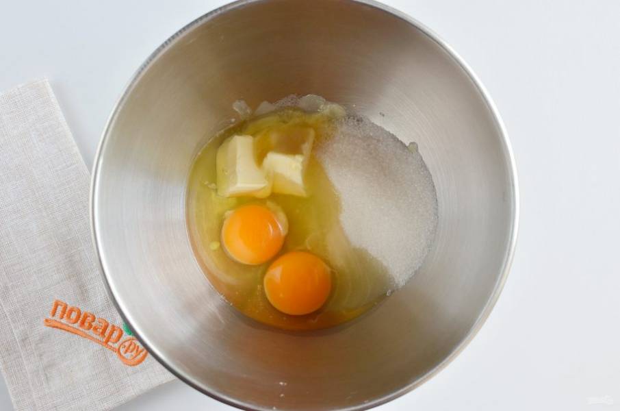 В чашу миксера выложите мягкое сливочное масло, сахар и яйца. Взбивайте венчиком около 5 минут.