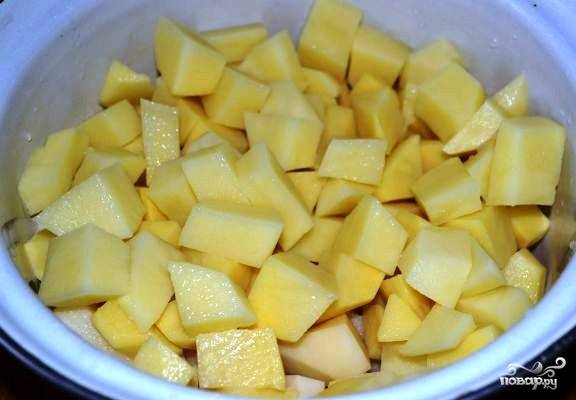 Картофель порежьте на кубики средней величины при помощи острого ножа. Если вы не будете готовить блюдо сразу же, то залейте картофель холодной водой. Тогда он не потемнеет, даже если вы отложите приготовления на несколько часов. 