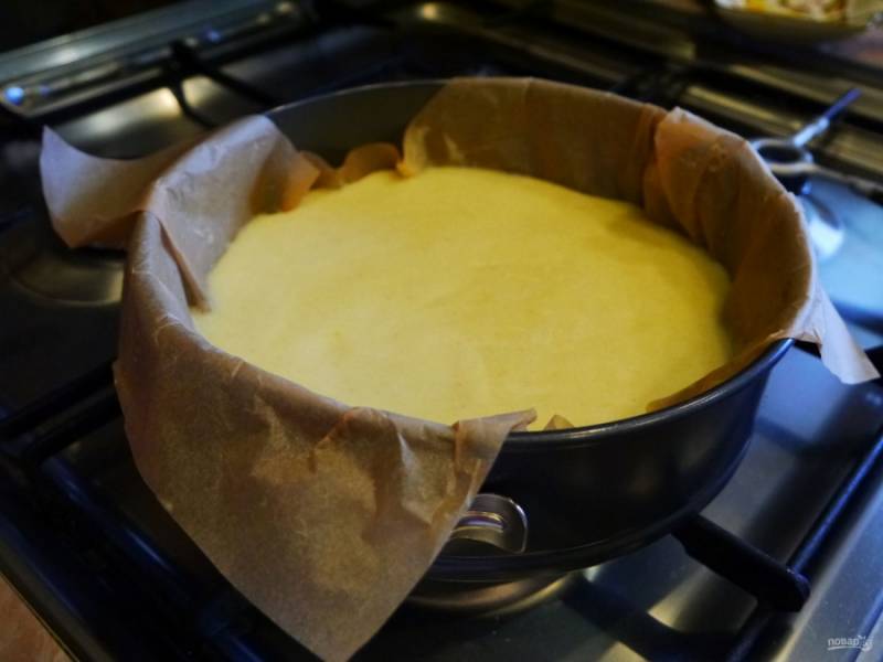 Форму для выпечки застелите пергаментом или смажьте сливочным маслом и присыпьте манкой.
Выложите в форму тесто.  