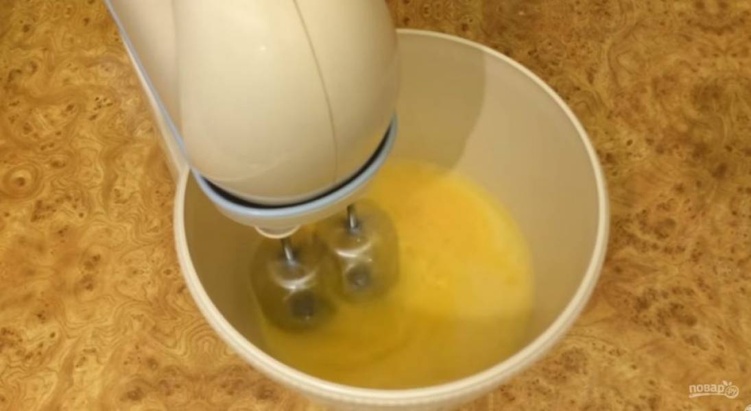 1. Яйца взбейте миксером на высокой скорости до образования пены. Не прекращая взбивать, добавьте небольшими порциями сахар. Взбейте до белой густой смеси. 