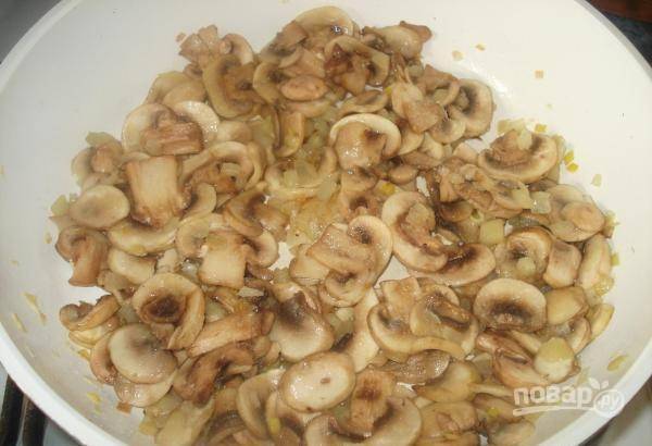 Затем добавьте в сковороду грибы. Перемешайте ингредиенты. Посолите их и поперчите. Жарьте всё вместе 5-7 минут.
