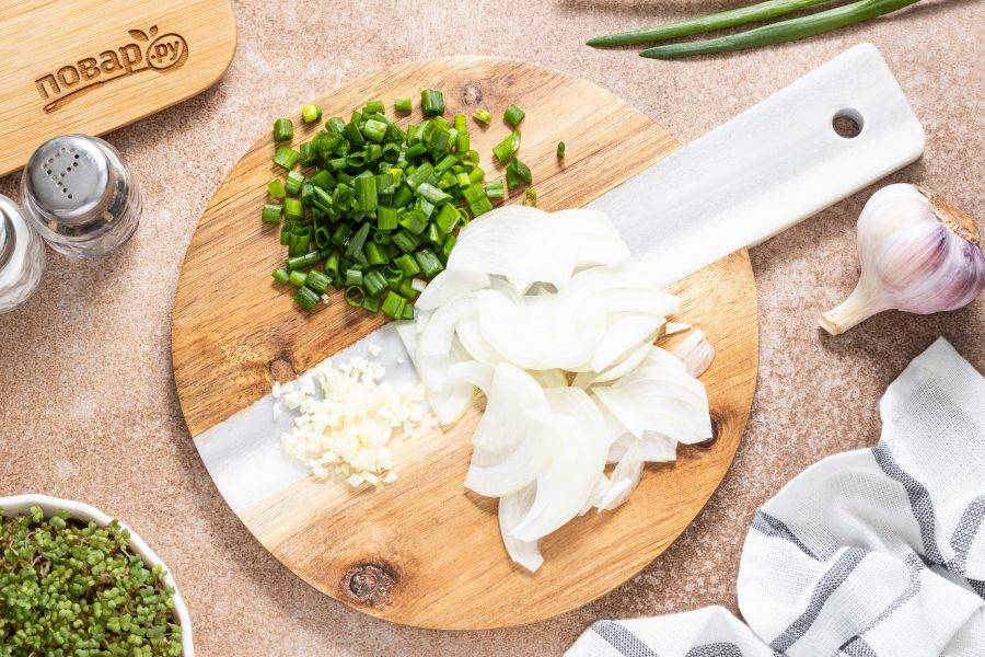 Пока жарятся грибы, нарежьте репчатый лук полукольцами. Чеснок и зеленый лук мелко порубите.